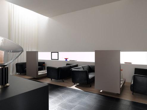 Hotellobby mit Trennwänden aus Holz und schwarzen Ledersofas